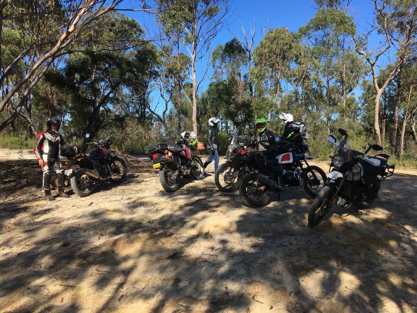 A group of motorcycles parked on a dirt road

Description automatically generated with low confidence